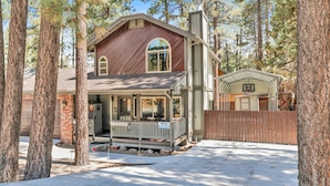 A two-story house with a front porch, a garage, and a basketball hoop.