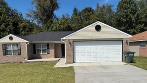 A single-story house with a garage, a brick exterior, and a well-maintained lawn. - Peaceful & Spacious Family Home (Savannah)