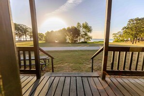 Une terrasse en bois offrant une vue sur la plage et les arbres.