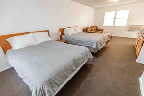 A hotel room with two beds, a chair, a dresser, and a window. - Admirals Cabin - Cozy cabin with a waterfront view. (West Tawakoni)