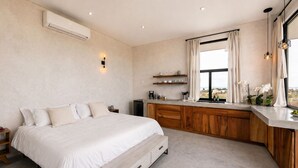 A bedroom with a bed, bedside table, and a window with curtains. - Trendy studio with incredible ocean views (Todos Santos)