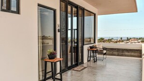 A balcony with a view of the sea, a potted plant, and a chair. - Trendy studio with incredible ocean views (Todos Santos)