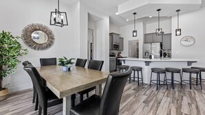 Eine moderne Küche mit grauen Schränken, einer weißen Arbeitsplatte und einem eingebauten Backofen.
