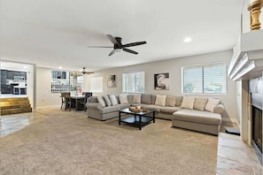 A spacious living room with a sectional sofa, a coffee table, and a ceiling fan. - Kierland Palms-Pool & Spa-Near Kierland Commons (Scottsdale)