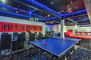 A room with a ping pong table, chairs, a red sofa, and a wall with silhouettes. - Spacious 8Br Private Pool Villa in Chalong (Phuket)