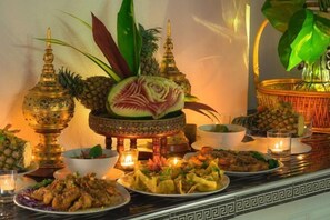 A table set with various dishes, a decorative centerpiece, and candles. - Spacious 8Br Private Pool Villa in Chalong (Phuket)