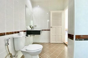 A bathroom with a toilet, sink, mirror, and a door. - Spacious 8Br Private Pool Villa in Chalong (Phuket)