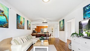 A modern living room with a sofa, coffee table, and artwork on the walls. - Chevron Renaissance Garden View (Surfers Paradise)