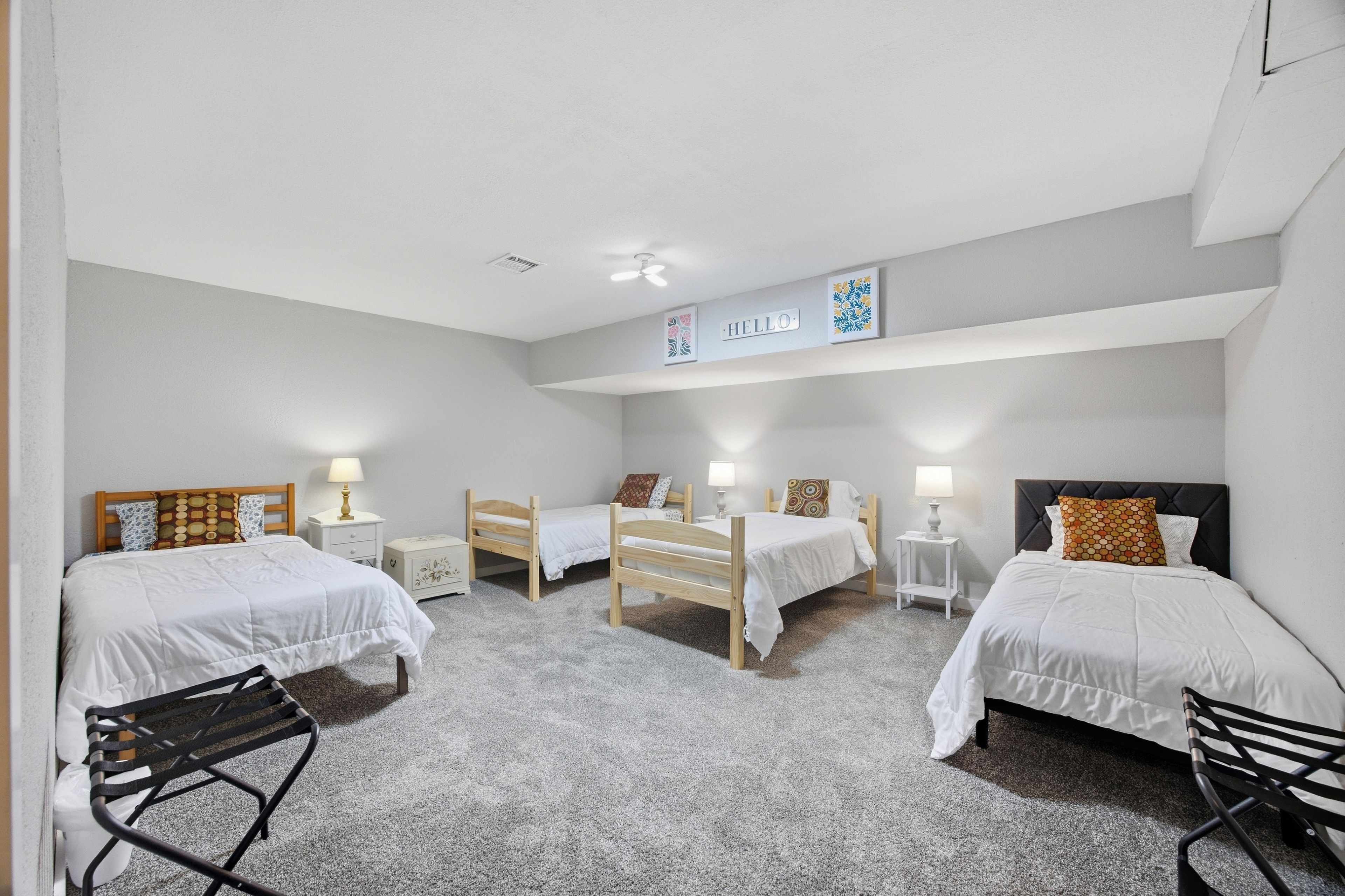 Ein Hotelzimmer mit zwei Einzelbetten, einem kleinen Schreibtisch, einem Stuhl und einem Deckenventilator.