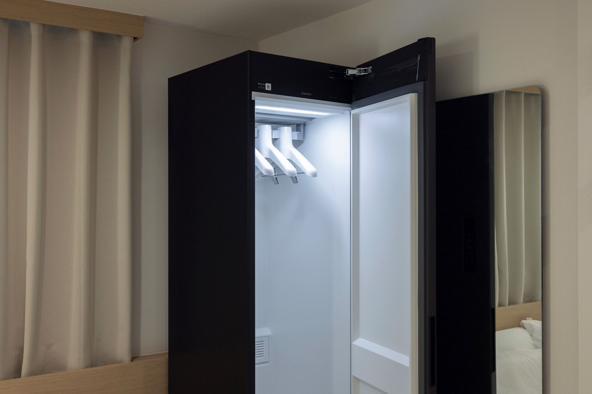 A modern hotel room with a built-in minibar and a separate sleeping area.