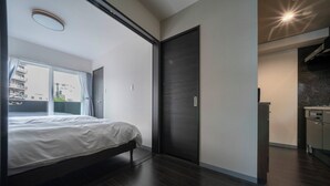Une chambre moderne avec un grand lit, une porte coulissante et une vue sur l’extérieur.