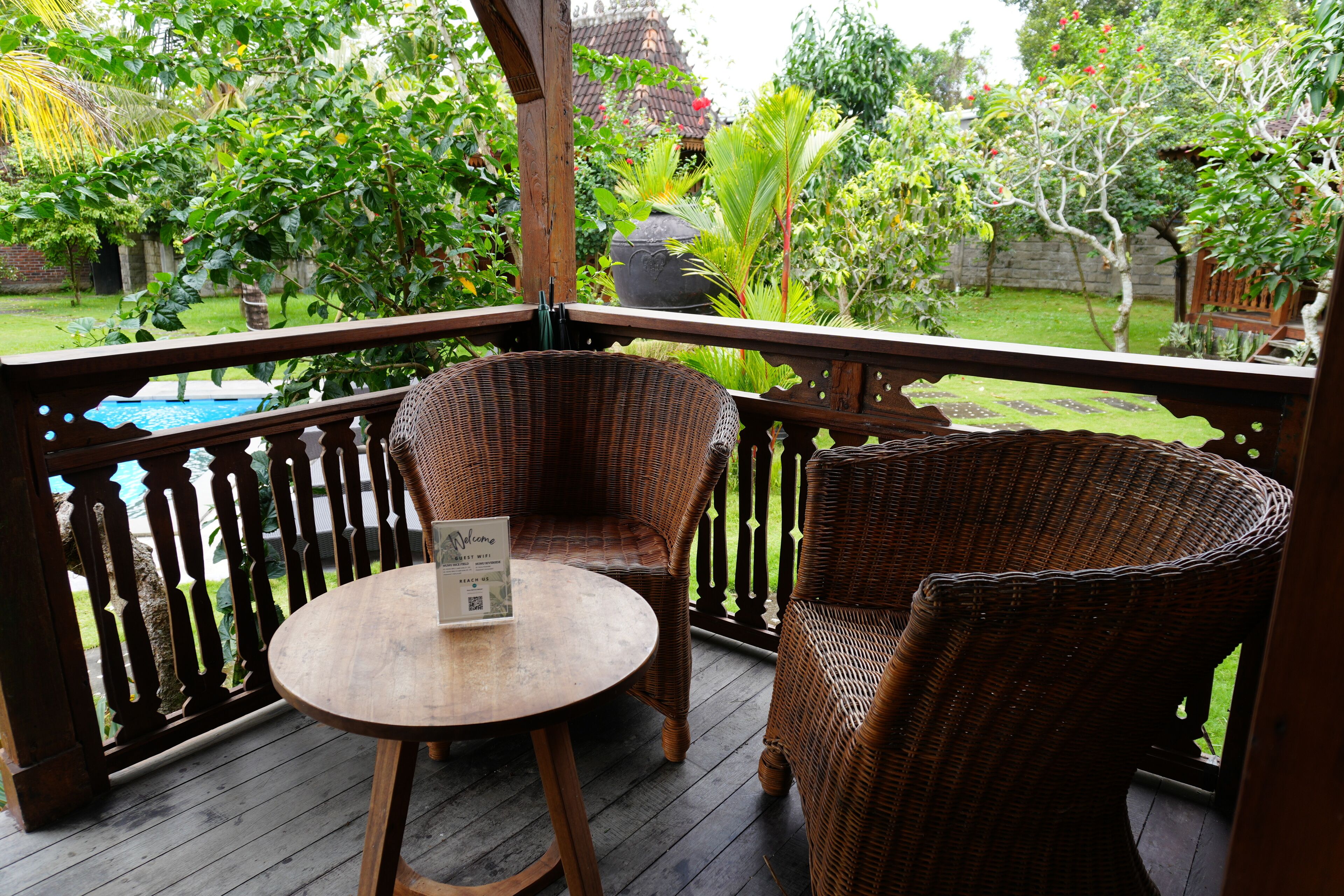 A wooden deck with wicker furniture, a table, and a sign indicating guest wifi.