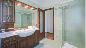 A modern bathroom with a double sink vanity, a large mirror, and a glass-enclosed shower. - A Due Passi Dal Bosco: Hillside Apartment with Garden&BBQ, Laveno Mombello, Italy (Laveno Mombello)
