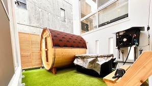 Uma sala de sauna com sauna de madeira, um banco e um ventilador.