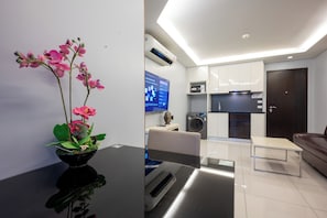 A modern kitchen with white cabinets, a built-in oven, and a microwave. - C-View Boutique (Pattaya)