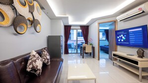 A modern living room with a leather sofa, a white coffee table, a flat-screen TV, and a decorative wall piece. - C-View Boutique (Pattaya)