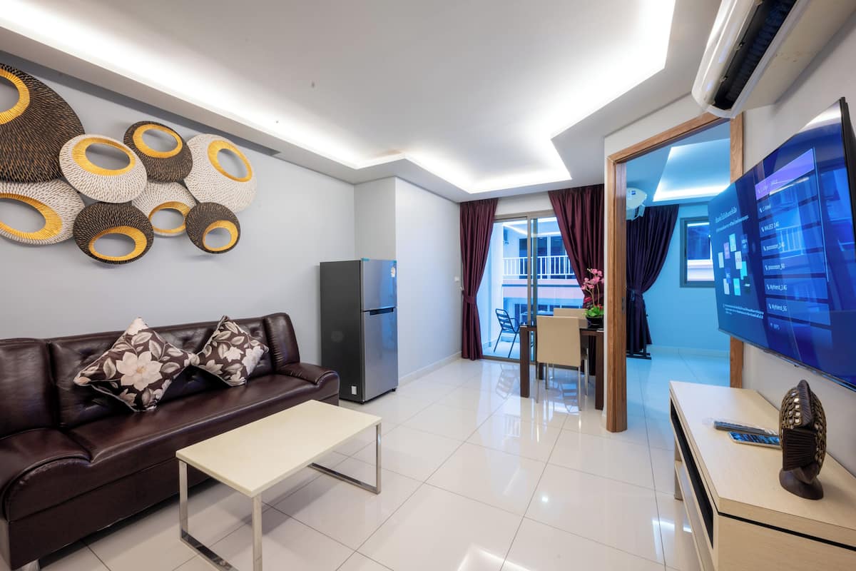 A modern living room with a sofa, coffee table, and a flat-screen TV.