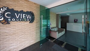 A modern boutique with a wooden wall and a glass reception desk. - C-View Boutique (Pattaya)