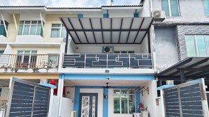 A two-story residential building with a covered entrance, a balcony, and a door with decorative panels. - Johor Senai (Senai)