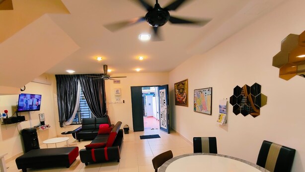 A modern living room with a black sofa, a round dining table, and a ceiling fan. - Johor Senai (Senai)