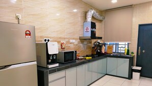 A modern kitchen with a refrigerator, microwave, coffee machine, and a stainless steel sink. - Johor Senai (Senai)