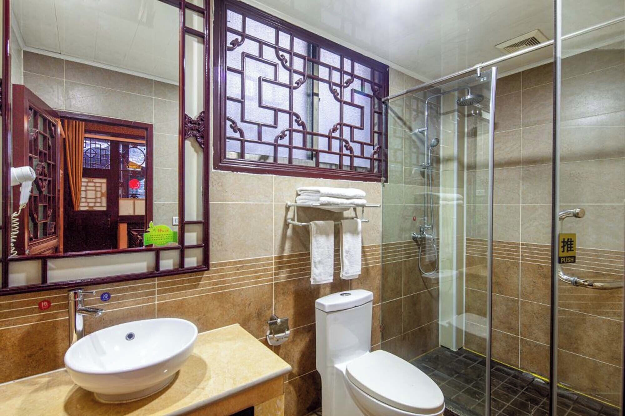 A bathroom with a sink, toilet, and glass shower enclosure.