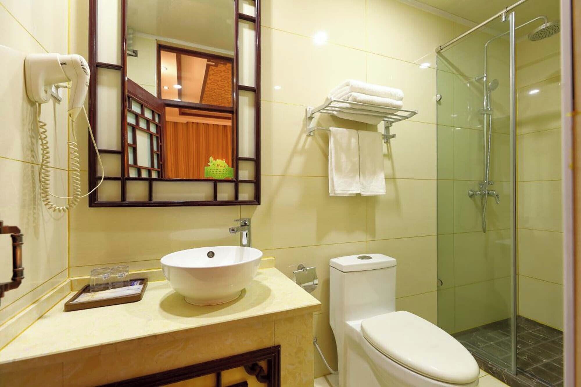 Un baño con lavamanos, inodoro y cabina de ducha de vidrio.