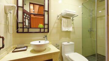 Un baño con lavamanos, inodoro y cabina de ducha de vidrio.