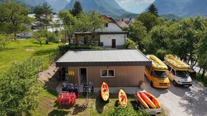 Eine Lodge mit Kajaks und Kanus, ein kleines Gebäude und Berge im Hintergrund.