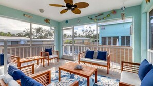A sunlit room with a balcony, wooden furniture, and a ceiling fan.