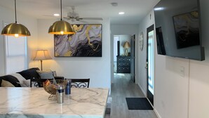 Una cocina moderna con encimeras de mármol, iluminación colgante y vistas al área de comedor.