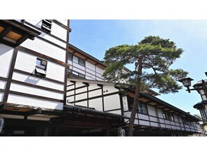 A traditional Japanese building with a wooden structure and white walls.
