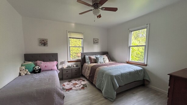 A bedroom with two beds, a ceiling fan, a nightstand, and a dresser. - Fabulous 2-bedroom cottage in Wurtsboro (Wurtsboro)
