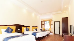 A hotel room with three beds, wooden headboards, a flat-screen TV, and a wooden dresser. - Khach San Cong Doan Sapa (Sa Pa)