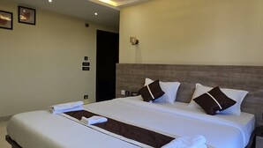 A large, modern bedroom with a large bed, a ceiling fan, recessed lighting, and a nightstand. - HOTEL BELSSESHE (Bolpur)
