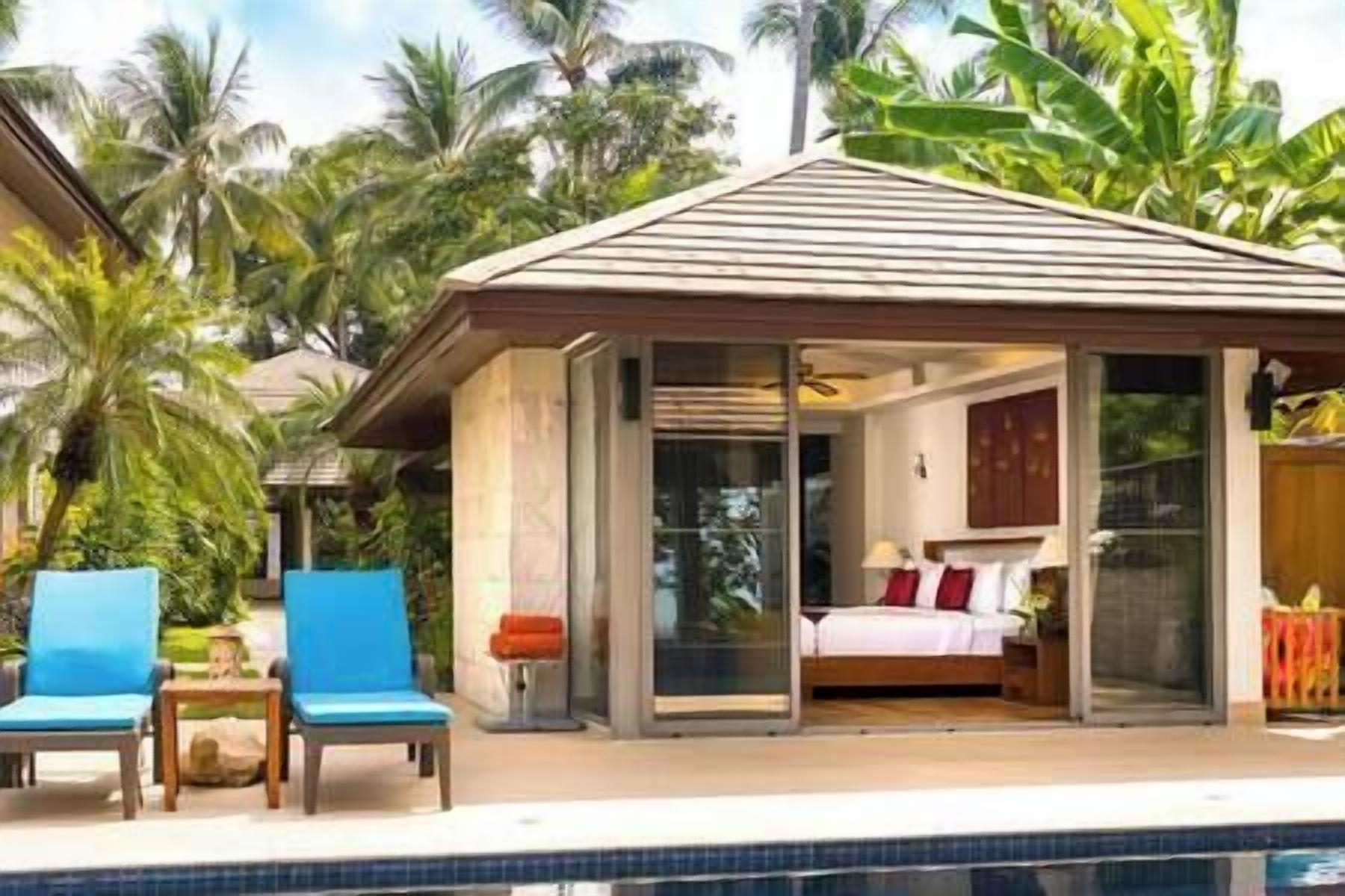 Quarto de resort com porta de vidro que dá para um quarto, piscina e área externa coberta com cadeiras.