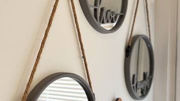 Three wall-mounted mirrors with ropes, each with a different word written inside.