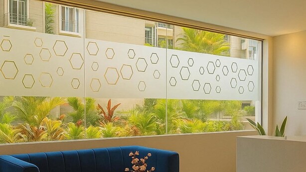 A modern lobby with a blue sofa, a round coffee table, and a reception desk. - Hotel Maski Suites (Hyderabad)