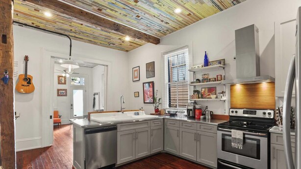 Una cocina moderna con una isla grande, electrodomésticos de acero inoxidable y un diseño de techo original.