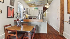 Una cocina moderna con una isla central, suelo de madera y techo con vigas a la vista.