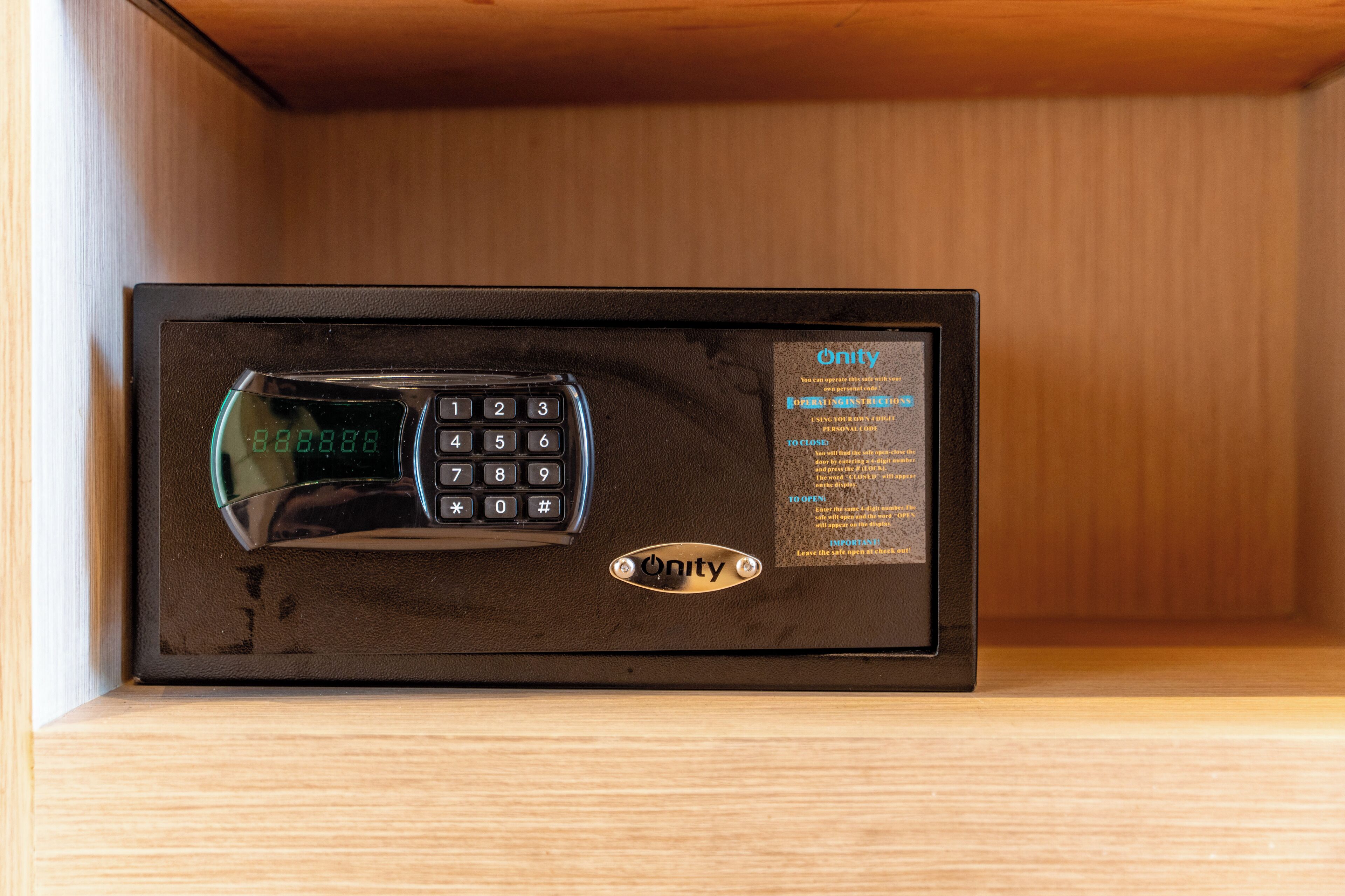 Un appareil électronique noir doté d’un clavier et d’un écran numérique, placé à l’intérieur d’une boîte en bois.