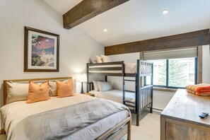 Um quarto com uma cama beliche, uma escrivaninha e uma janela com persianas.