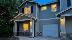 Ein zweistöckiges Haus mit Garage, überdachter Veranda und einem angelegten Vorgarten.
