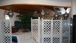 A room with a bed, decorative hanging lamps, and a plant. - Apartment Römerstraße 64-persons, 40sqm, 1 bedroom, balcony or terrace (Bad Reichenhall)