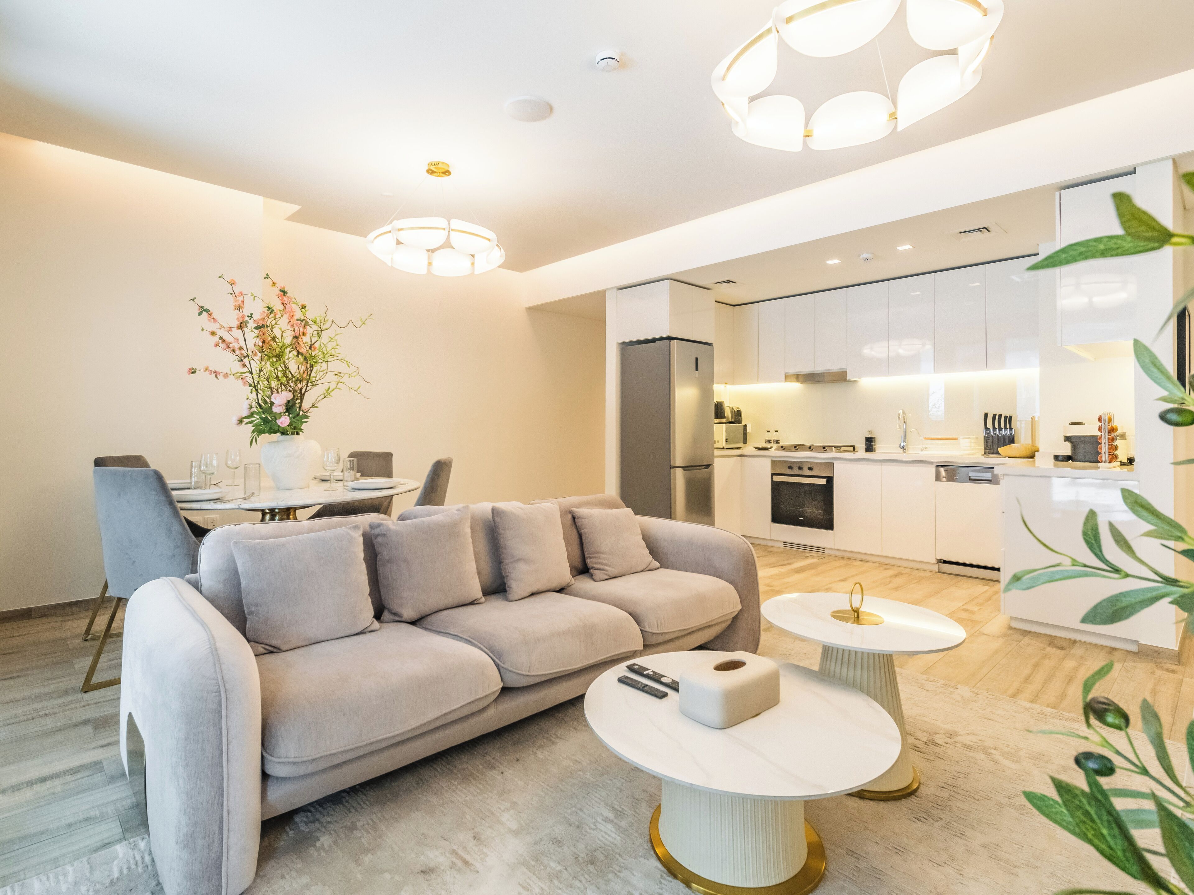 Een moderne woonkamer met een bank, salontafel en eethoek.