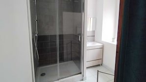 A modern bathroom with a glass-enclosed shower, a white sink, and a mirror. - "Le Nid Dauphinois" fully equipped - Ideal for business, couples & families! (L'Albenc)