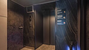 A modern elevator interior with marble walls and a digital display.