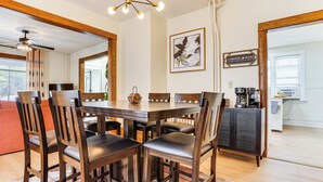 A dining area with a wooden table and chairs, a coffee bar, and a framed artwork on the wall. - 1 Mi to University: Spacious Home in Minneapolis! (Minneapolis)