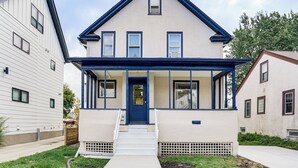 A two-story house with a blue front door, white siding, and a small porch. - 1 Mi to University: Spacious Home in Minneapolis! (Minneapolis)