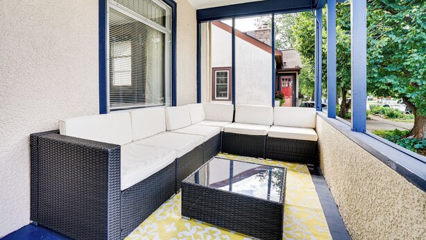 A covered outdoor seating area with a sectional sofa and a glass coffee table. - 1 Mi to University: Spacious Home in Minneapolis! (Minneapolis)